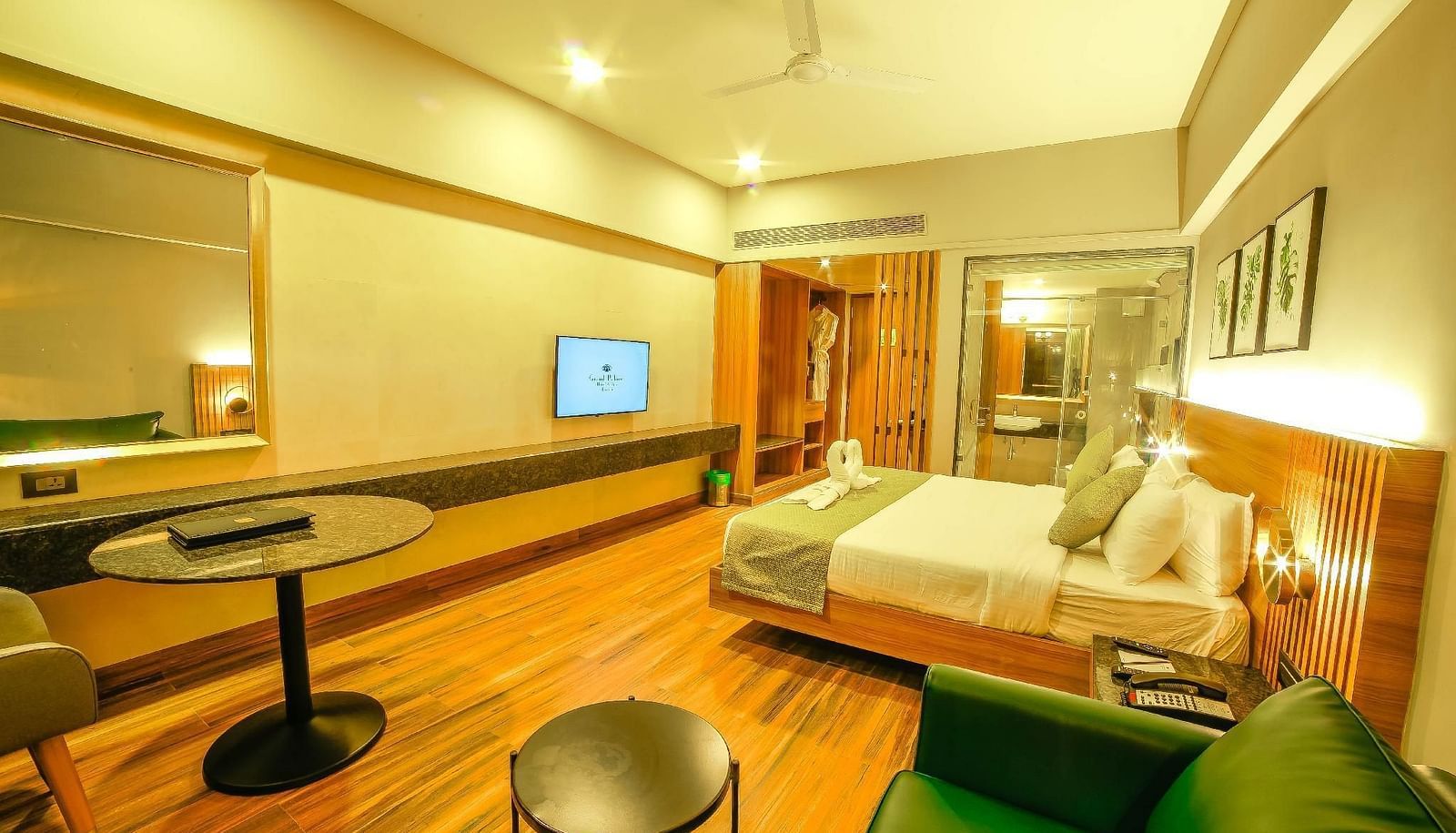Side view of the double bed and the sitting area in the Superior Balcony Room at Grand Palace, Yercaud