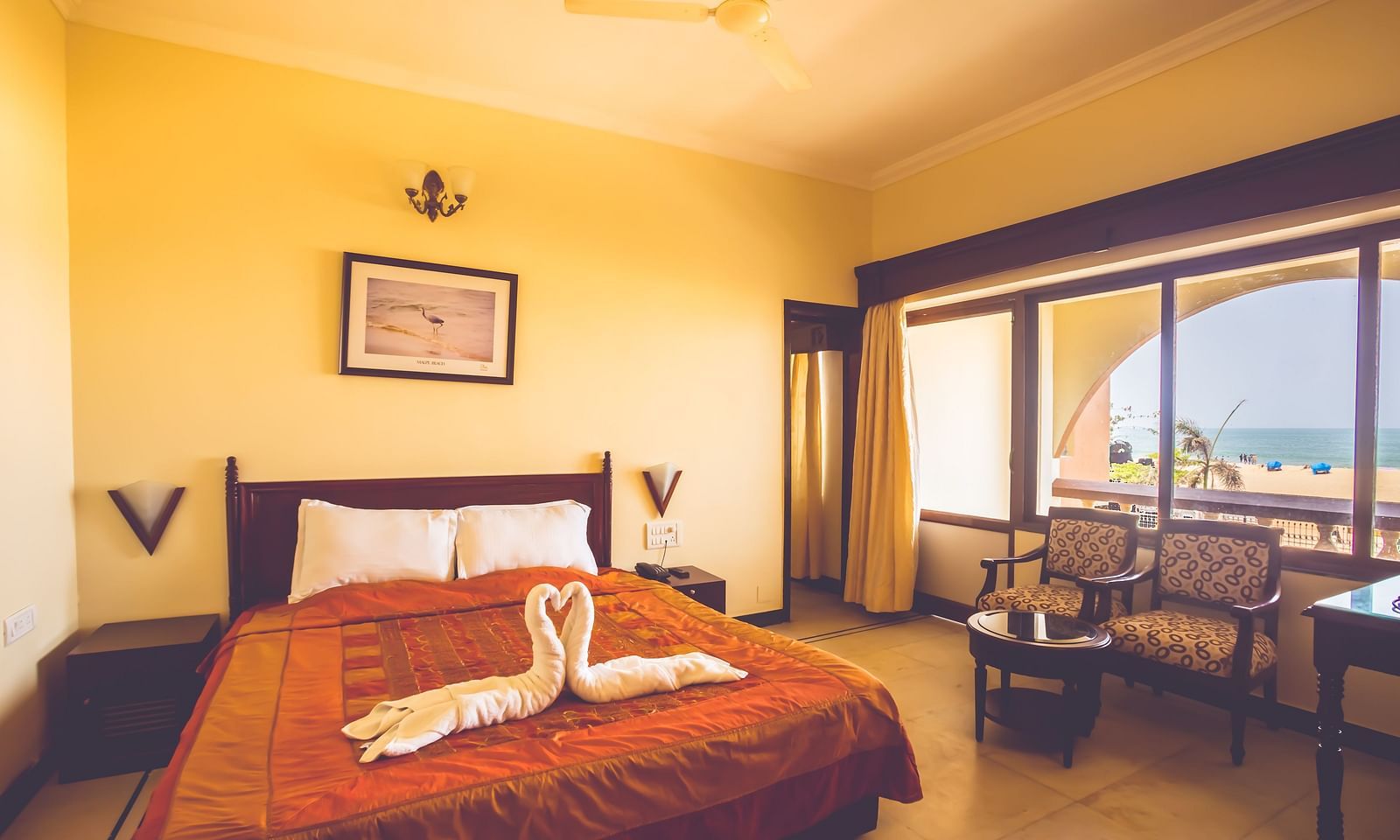 A room at Paradise Isle Beach Resort, Udupi with a double bed, seating arrangement and views of the sea from the window
