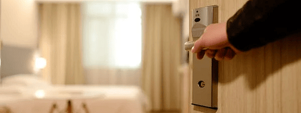 A person opening the door to a room
