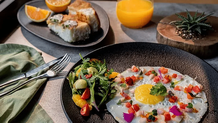 Plate of food with eggs and juice served on a table at Karma Chalets.