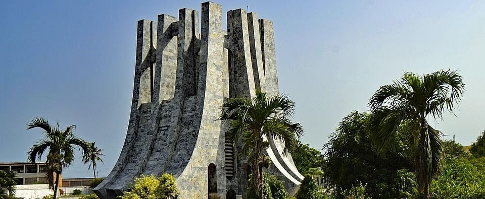 Kwame Nkrumah Mausoleum in Accra, Ghana, with palm trees and manicured lawns under a clear blue sky.