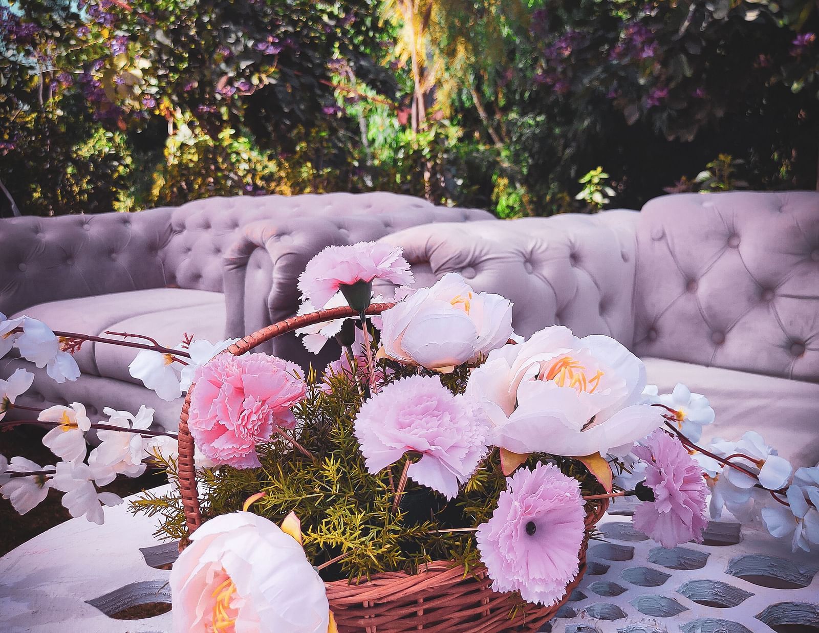 Seating with couches, flowers, and decorative lighting.