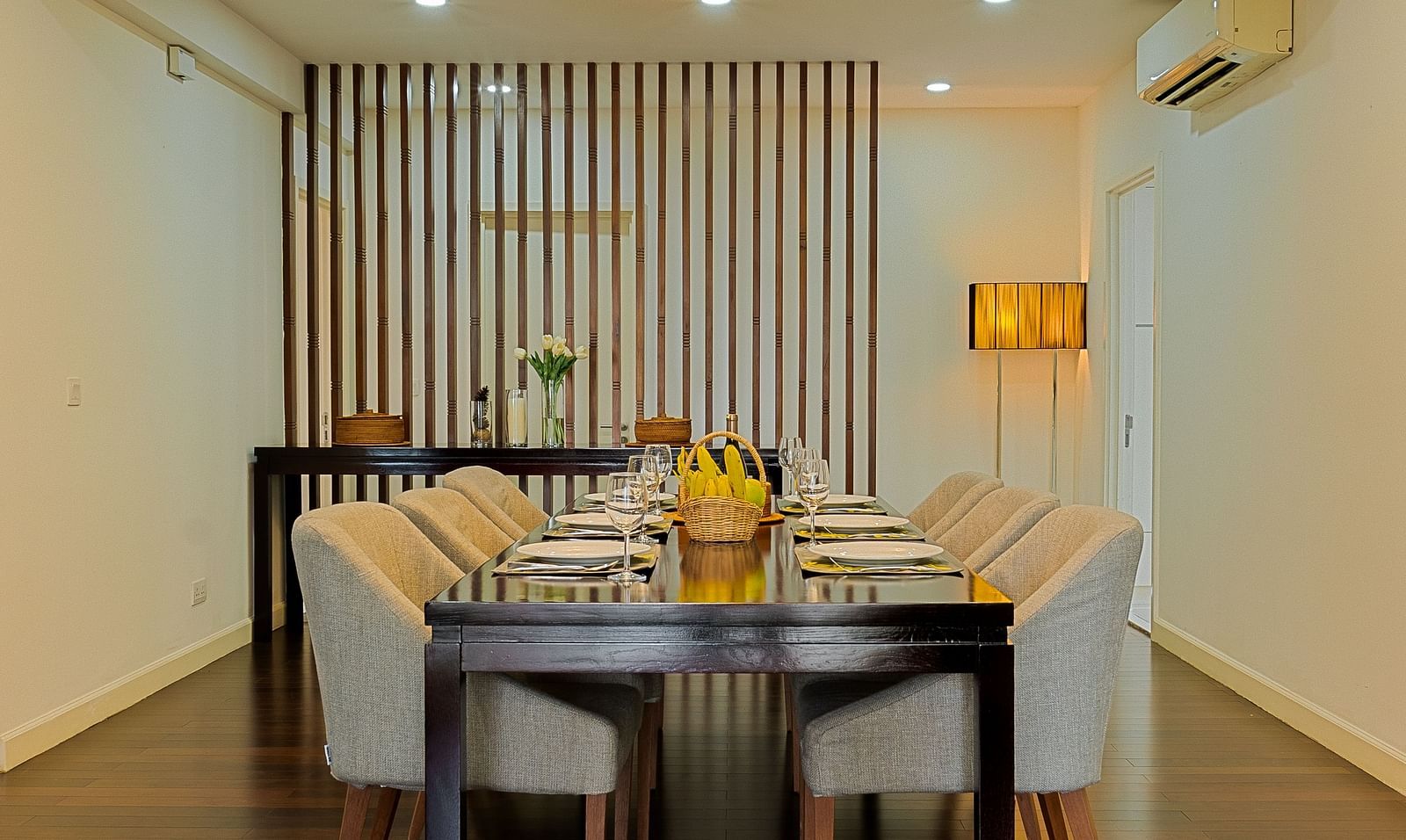 A dining area with a wooden table, chairs, and a chandelier overhead | Penthouse | Central Mansions, Phnom Penh
