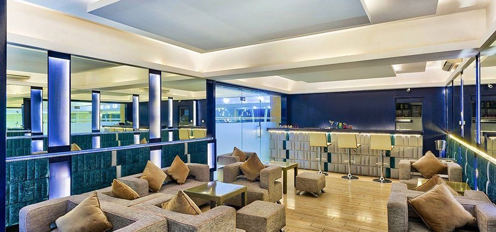 Indoor seating with rattan chairs and blue décor at Grande Bay Resort & Spa.