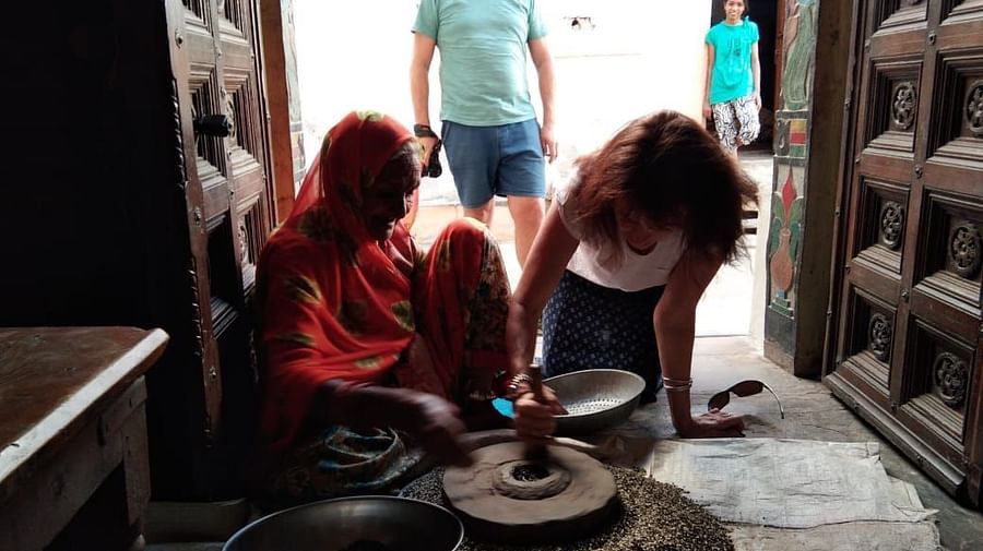 image of a few tourists observing a potter at work and trying out the craft