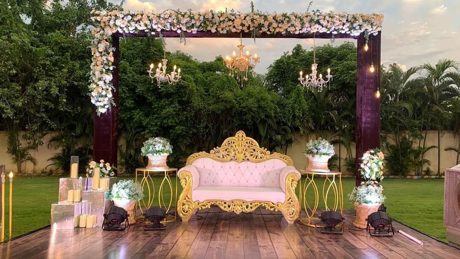 Ornate outdoor stage adorned with flowers and chandelier lighting at Ilara Hotels & Spa, OMR, Chennai