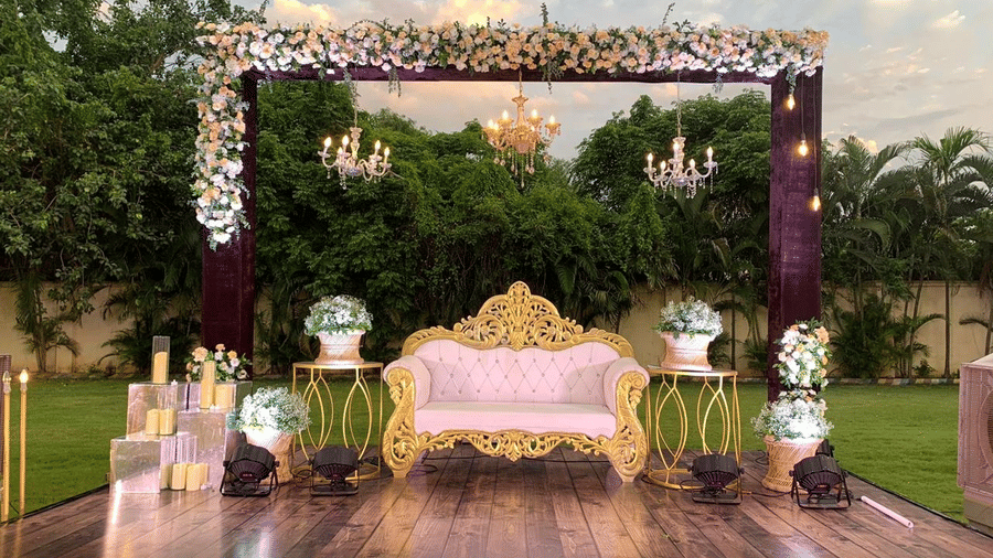 Ornate outdoor stage adorned with flowers and chandelier lighting at Ilara Hotels & Spa, OMR, Chennai