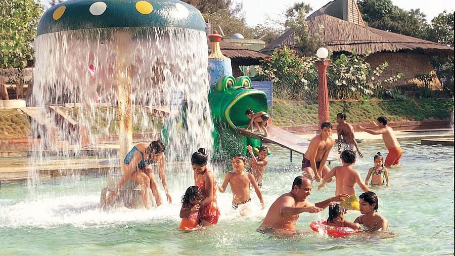 Water Kingdom - a group of children with their parents playing in a pool during daytime
