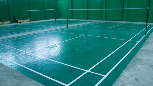 An indoor badminton court at the best resort in Bangalore, with nets and markings | Ramanashree California Resort