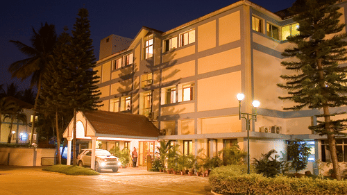 The building exterior of the best resort in Bangalore at night, with lights and pathways | Ramanashree California Resort