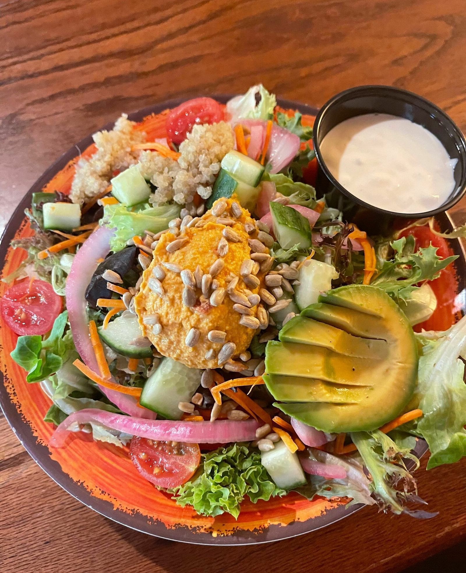 a bowl of a nutritious salad served with a salad dressing beside it at Tapoco Tavern - Historic Tapoco Lodge