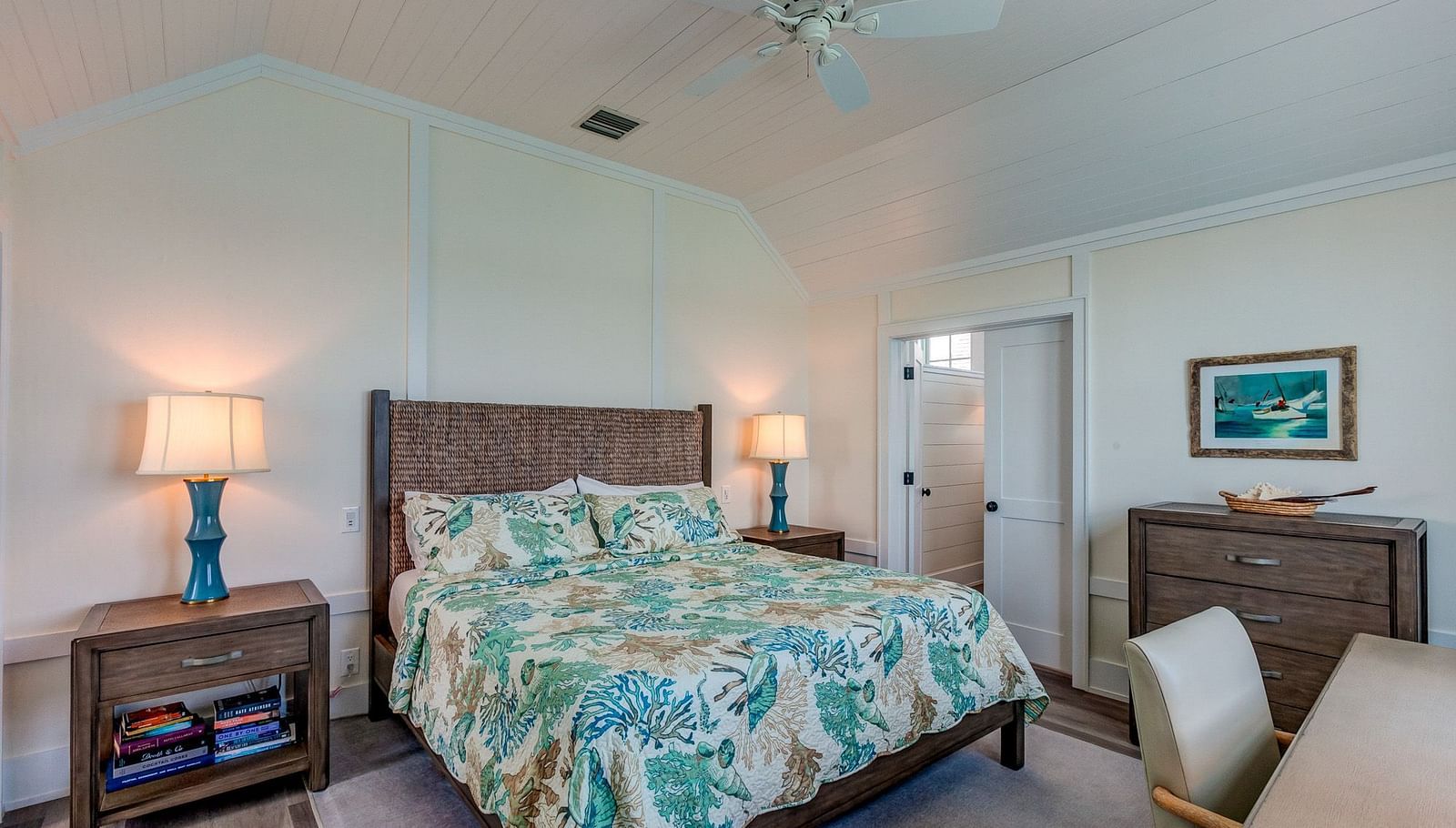 Bedroom with a patterned bedspread, wooden furniture, and a ceiling fan | Abaco Inn