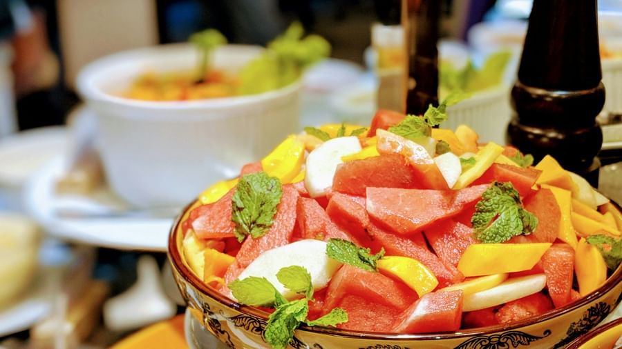 Bowl of freshly cut watermelon, papaya, and guava garnished with mint leaves served at Fireflies Resorts, Kabini.