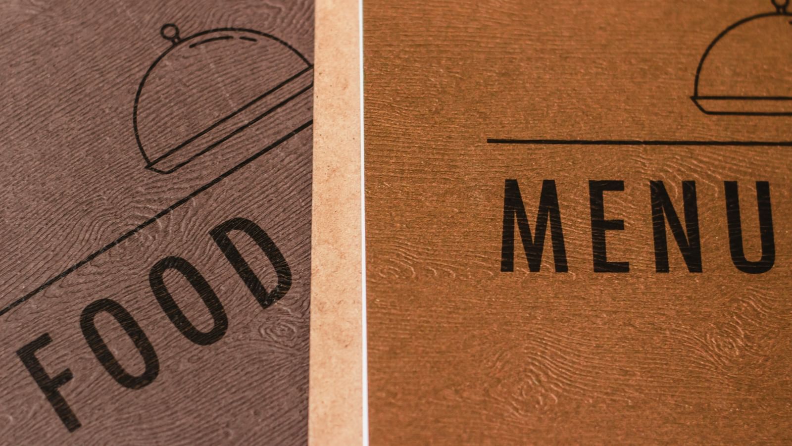 A close-up of a brown menu cover with FOOD and MENU printed on it