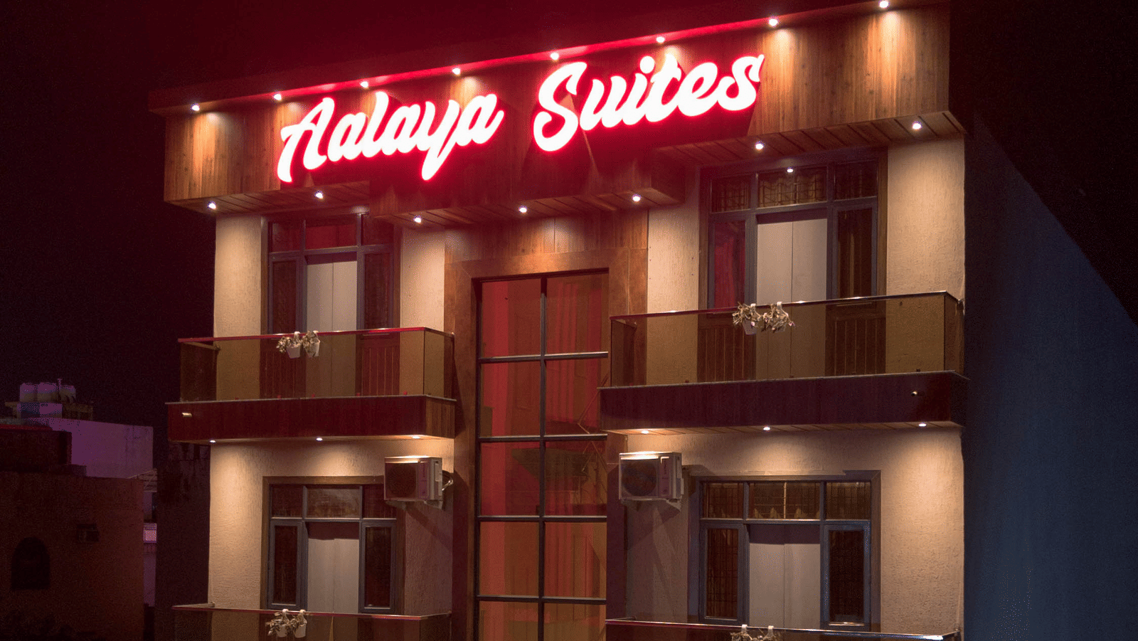 Exterior view of the multi-storey hotel building with 'Aalaya Suites' written on top under a dark sky - Perfectstayz Value Aalaya Suites, Haridwar