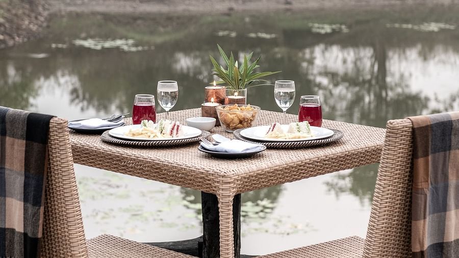 A dining setup for a couple with lake-view at Saccharum Safari Lodge, Balaghat