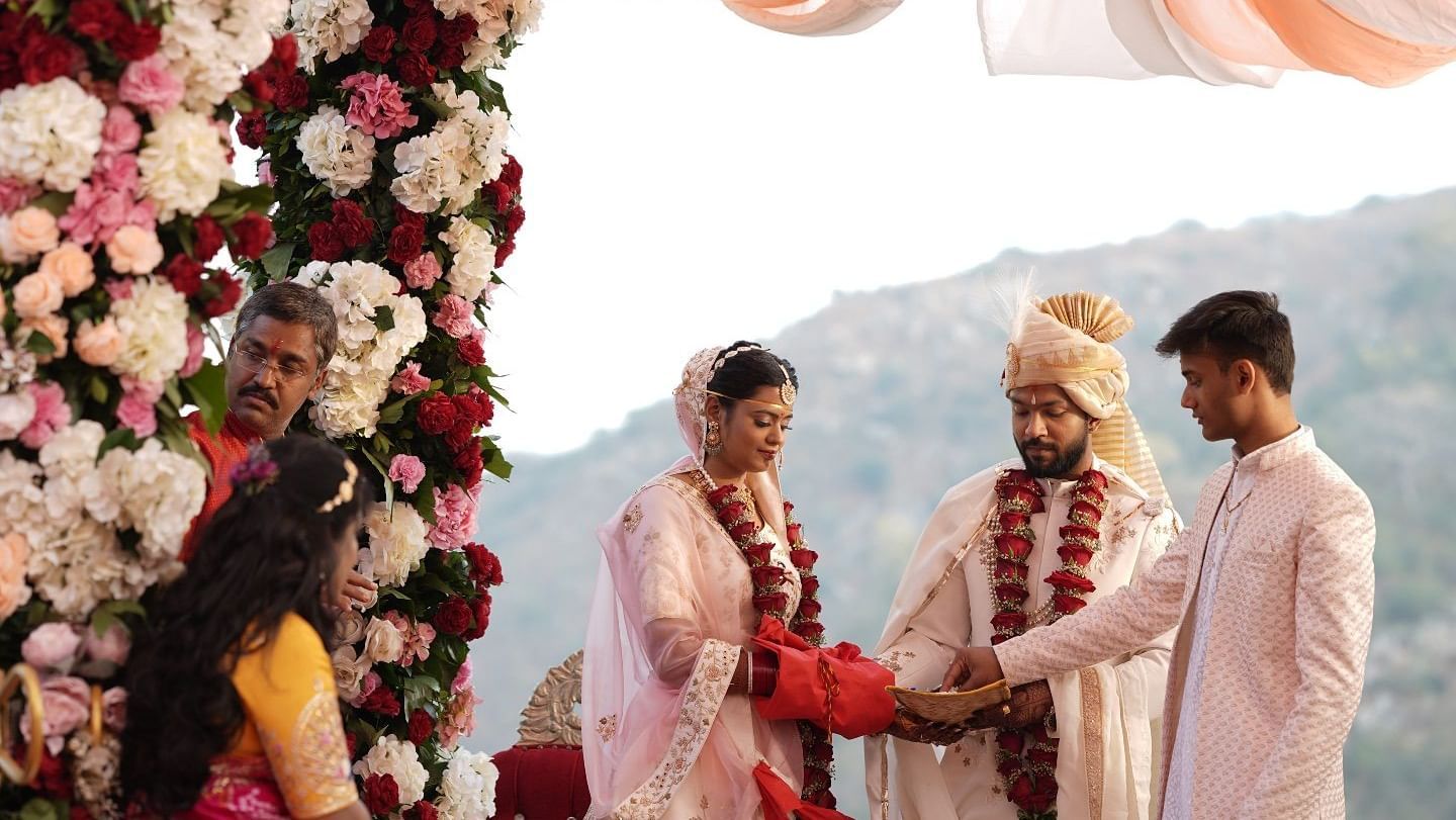 Wedding magazine featuring Lavisha and Rikin placed on a cushioned seat, hinting at their elegant Kumbhalgarh celebration.