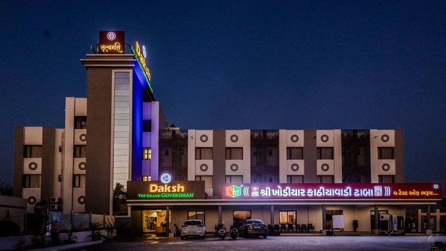 Daksh The Grand Gowardhan, Dwarka, illuminated at night under a star-lit sky.