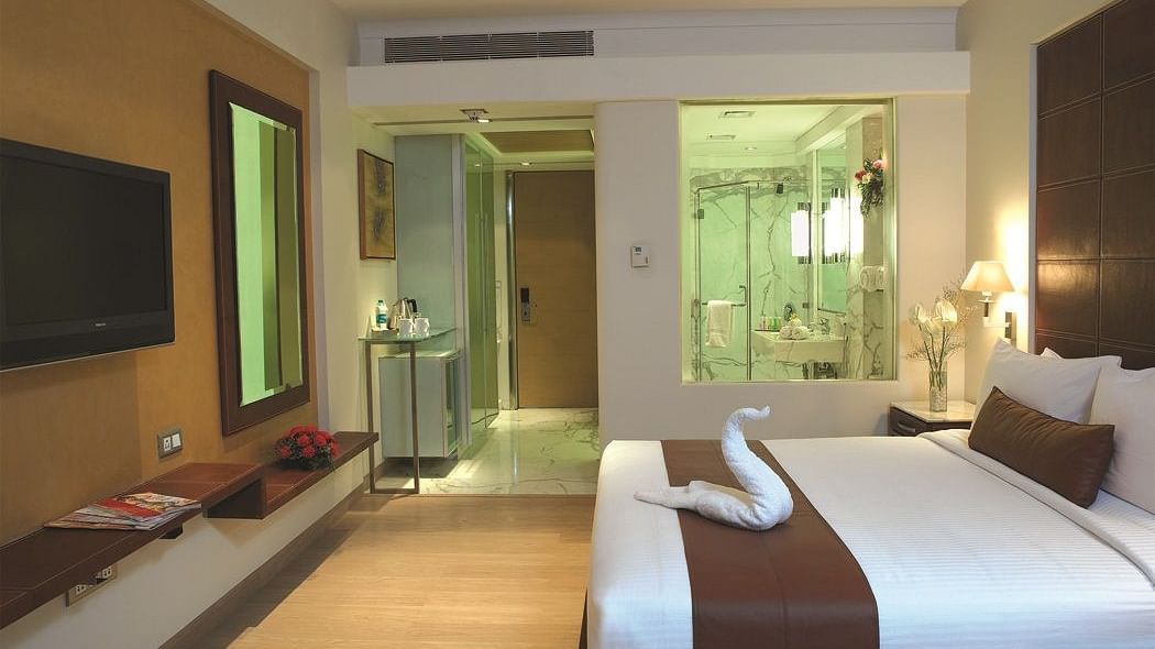 Shot of reflection room at our hotel featuring a king size bed that as a towel art, flat screen television, expansive window | Mirage Hotel