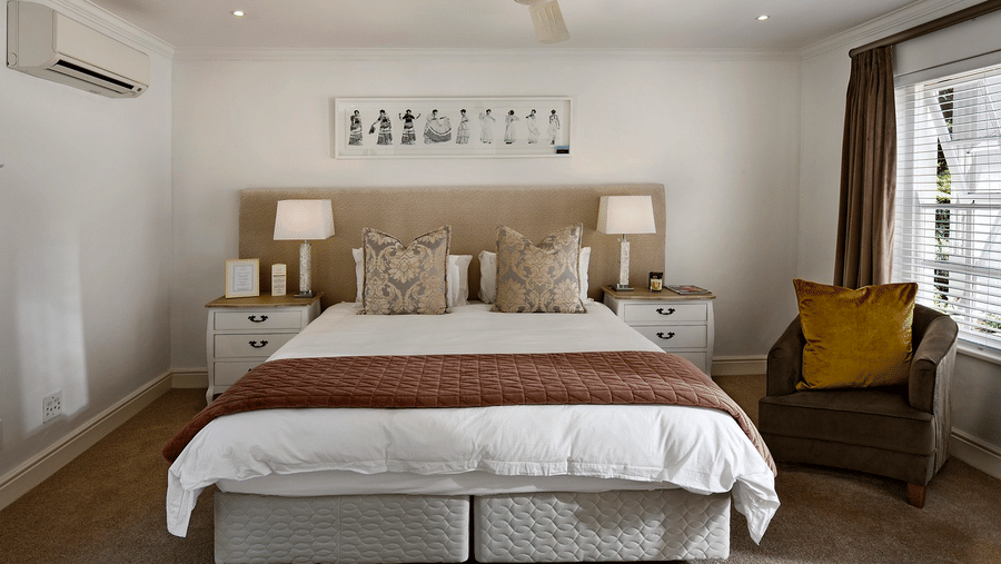 A double bed with a ceiling fan hanging over it in a bedroom.