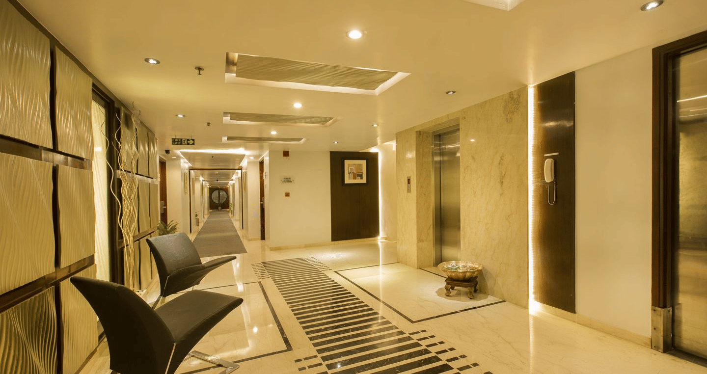 Spacious corridor of The Citrine with light-coloured walls, patterned floor, and doors leading to rooms.