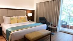 Superior Room at Golden Tulip, Goa Vagator with a double bed, a sofa chair and a coffee table