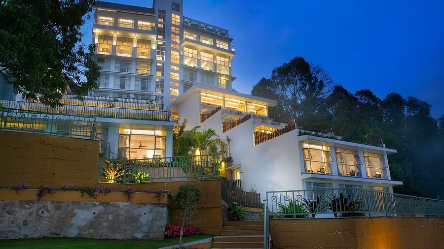 Facade view of Fragrant Nature Munnar illuminated at night.