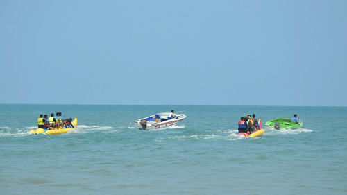People enjoying banana boat ride on the beach