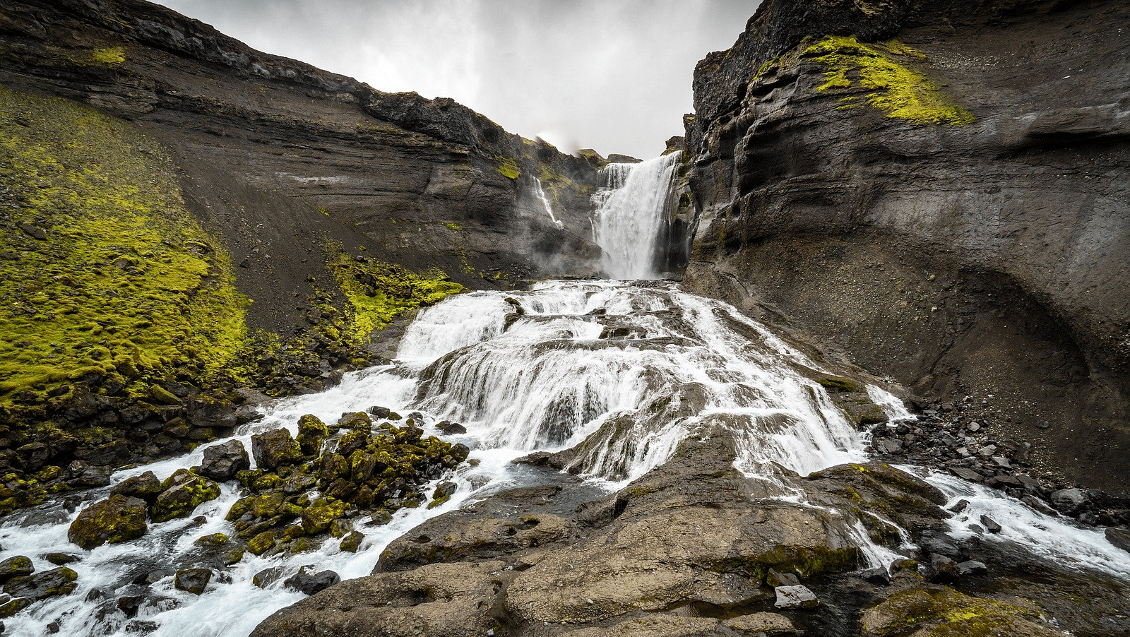 an image of the water gushes over the rocks during the waterfall