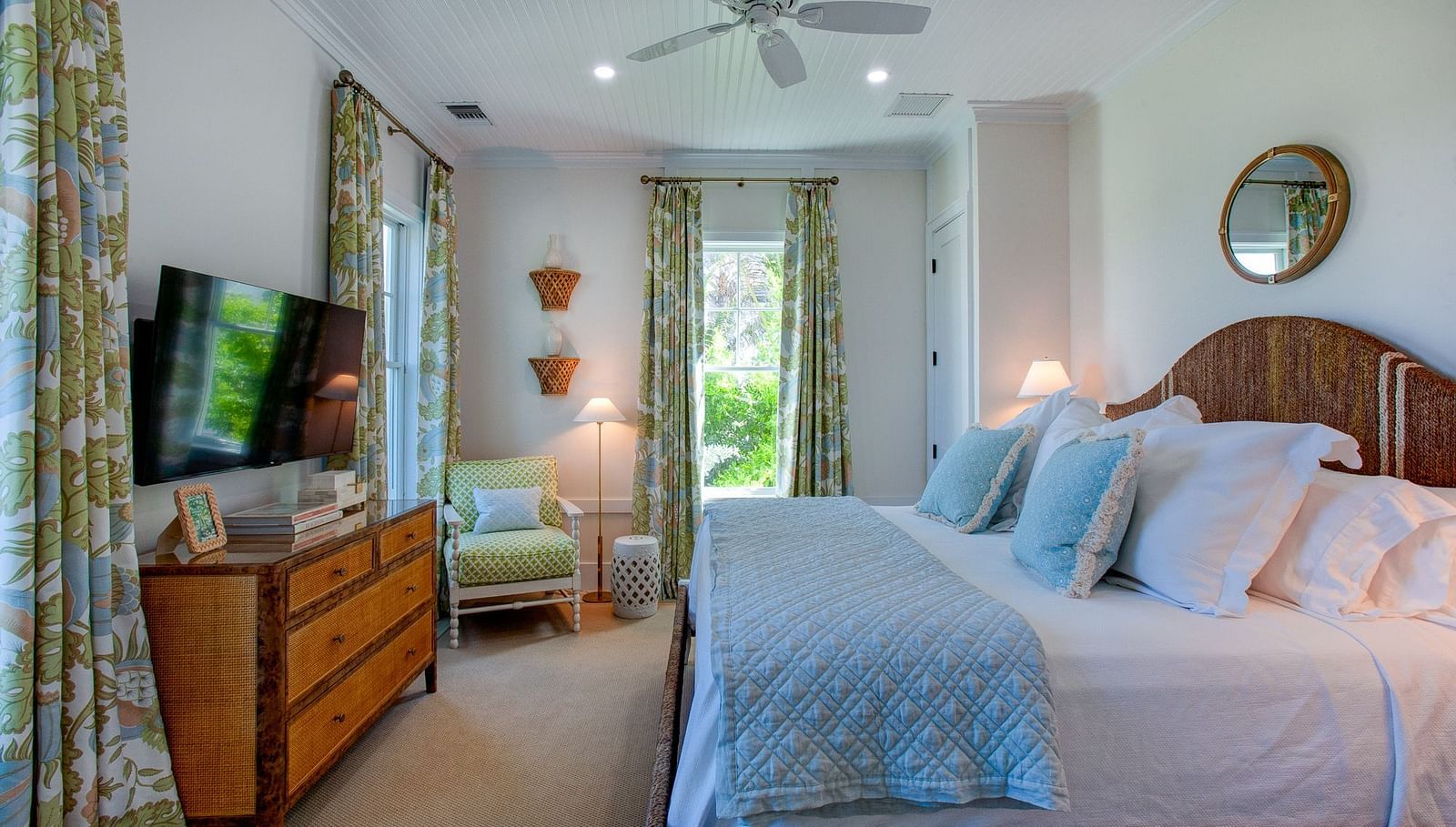 A well-appointed bedroom at Abaco Inn featuring a large bed featuring a headboard, bedside tables with lamps, and a television mounted on a dresser 