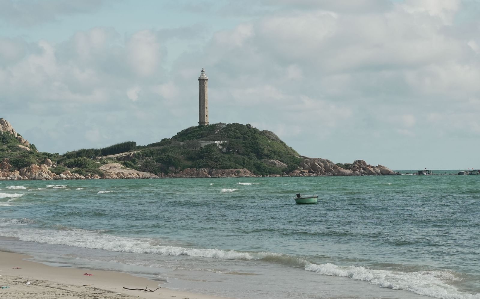 The iconic Ke Ga Lighthouse on a small island near the ocean, viewed from a distance at WoCAL Retreat Ke Ga.