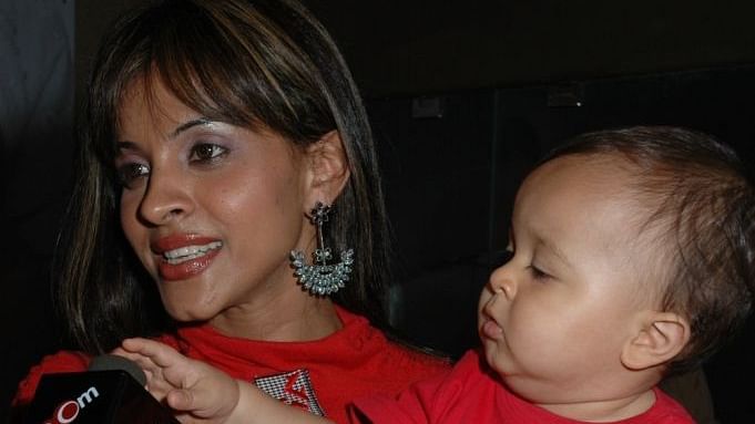 a woman holding a child while speaking to a reporter - IOSIS Spa & Wellness