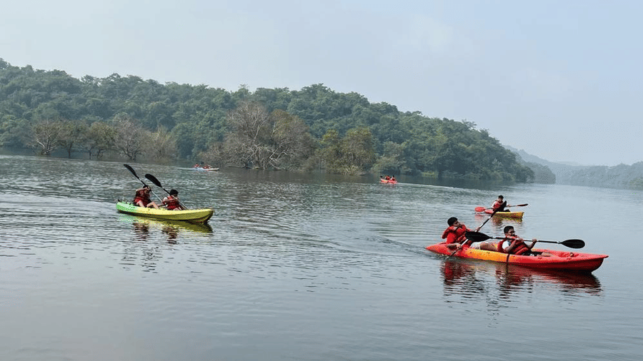 Guests kayaking peacefully across a serene lake surrounded by natural beauty.