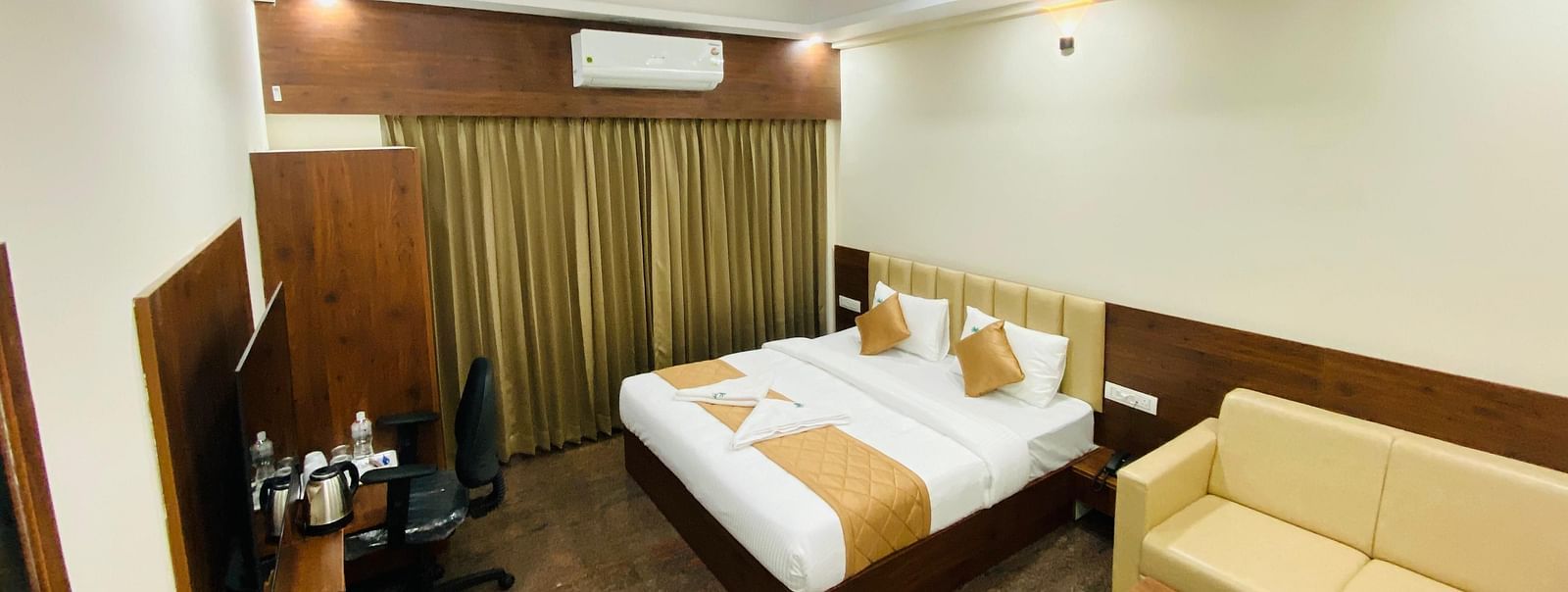 Cosy guest room with a comfortable bed and seating area at Hotel Sahara Tree.