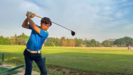 image of a person playing golf dressed in a blue polo t shirt at karma lakelands in gurgaon