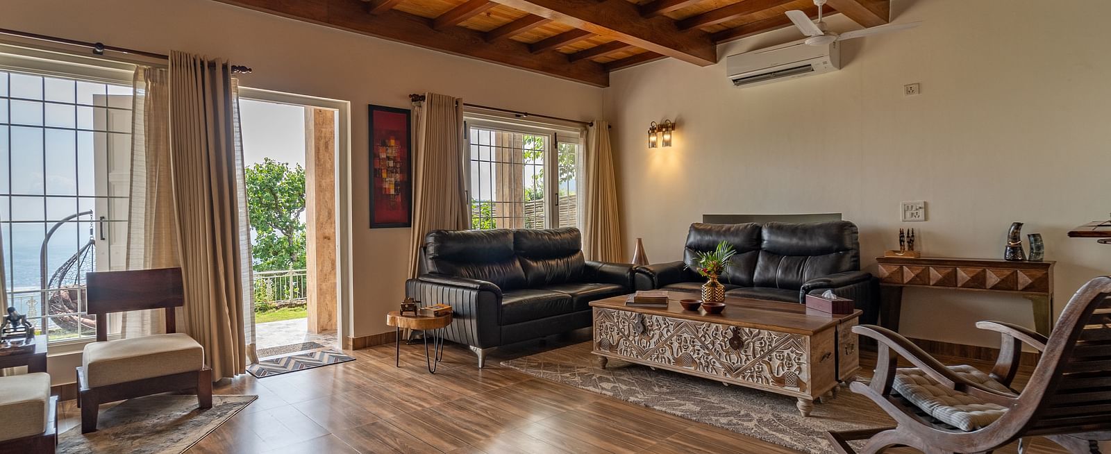 an overview of a living room with sofas and a coffee table inside one of the rooms - neer ganga Resorts