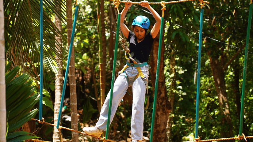 A participant engaging in an adventure activity while wearing safety gear and a harness - Stone Wood Nature Resort, Gokarna
