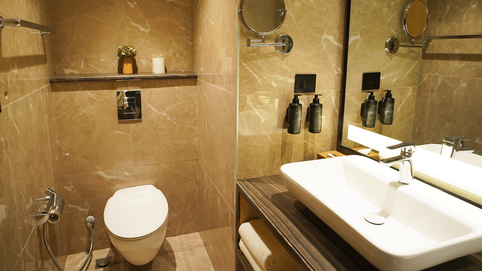 Bathroom view with toilet, wall-mounted toiletries, and a vanity mirror - Ramada Encore by Wyndham Gurugram Dwarka Expressway