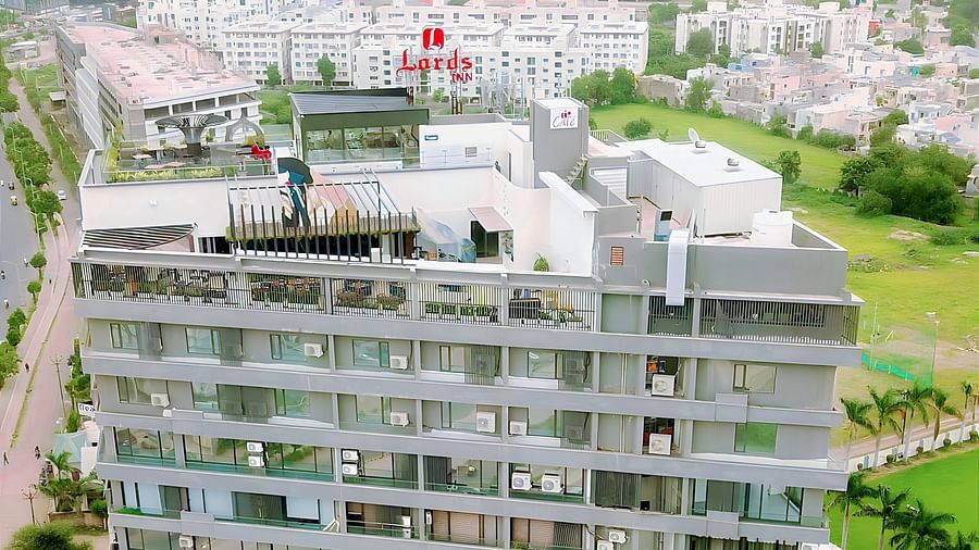 a aerial view of Lords Inn Rajkot showcasing the neighbouring area with lush greenery and other buildings surrounding it