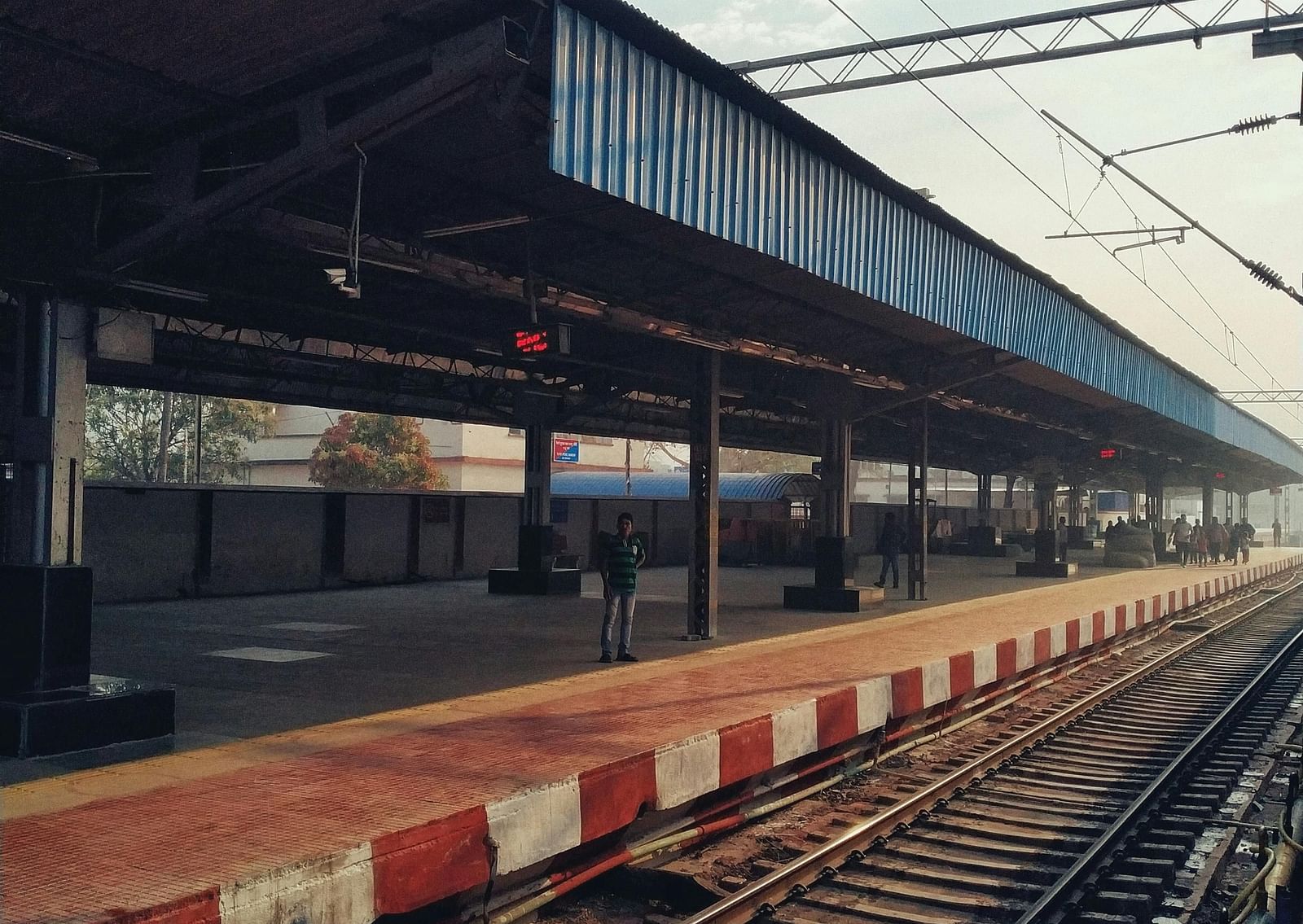 Railway tracks with an empty station in the backdrop during the day