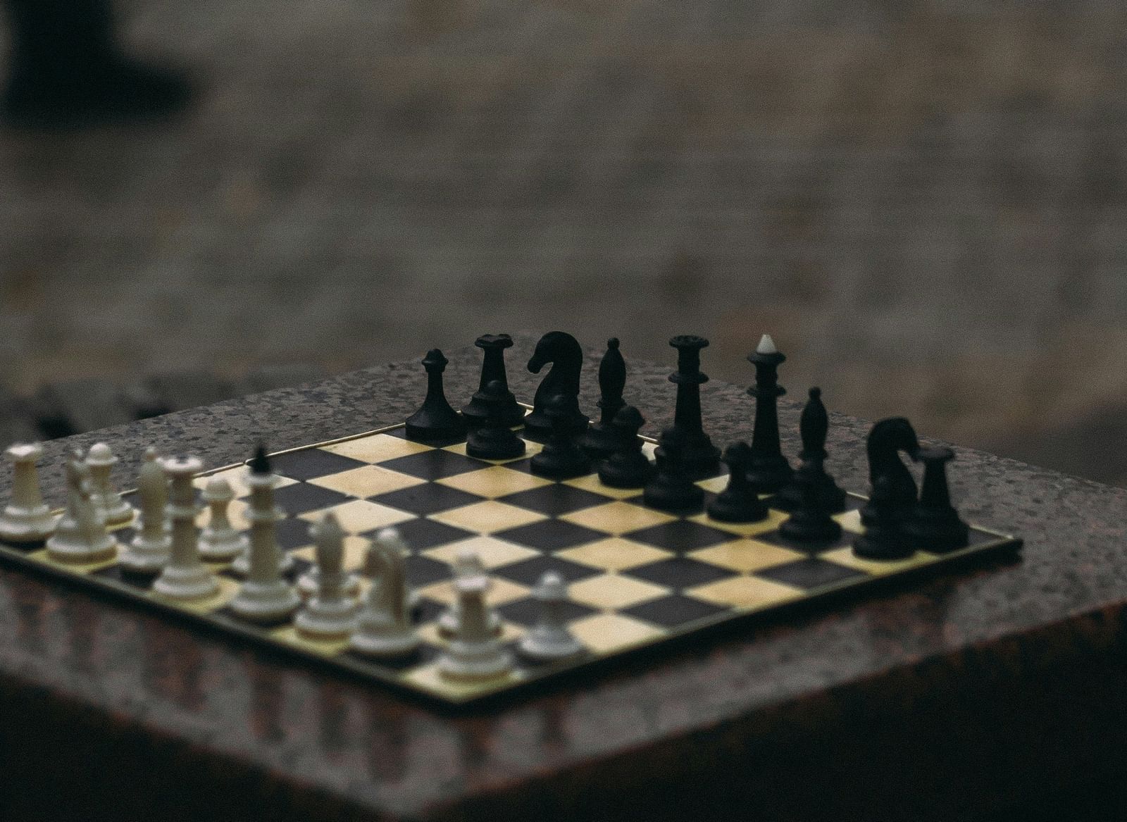Close-up of a chessboard with chess pieces set on a table.