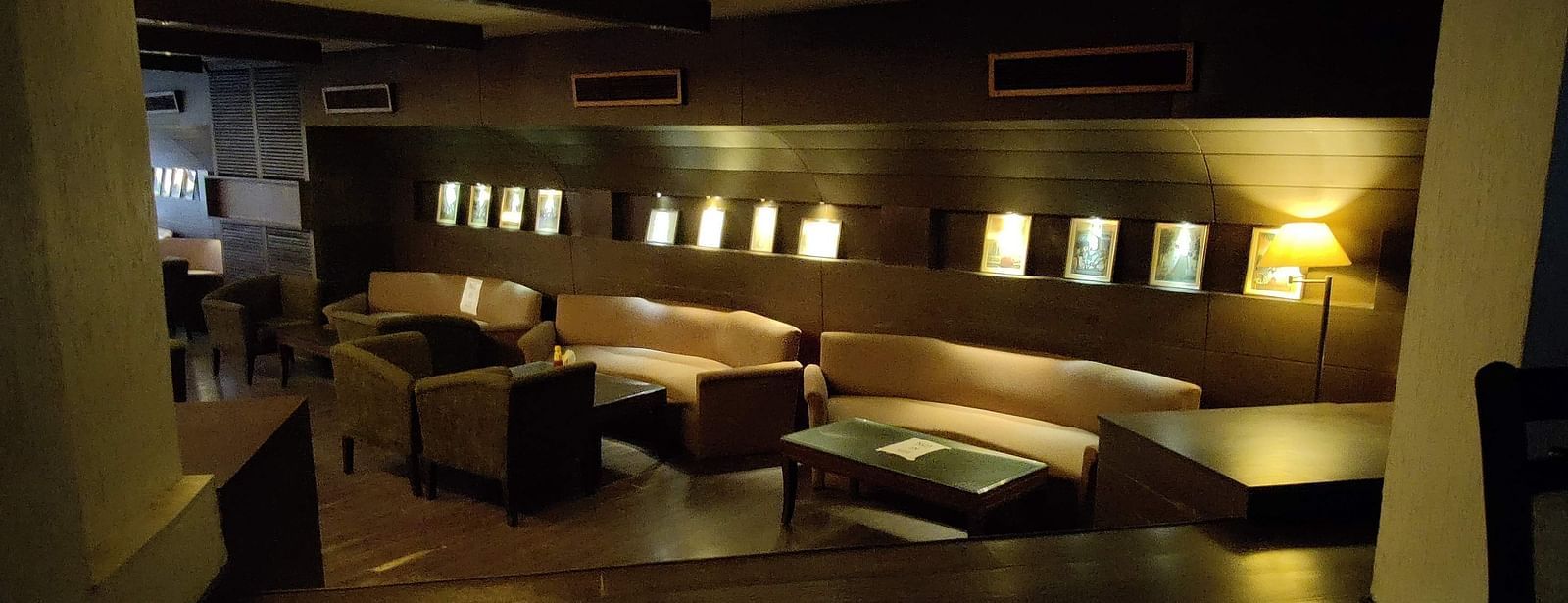 A dimly lit indoor seating area at 24 Karats bar - Hotel Gold, Panipat