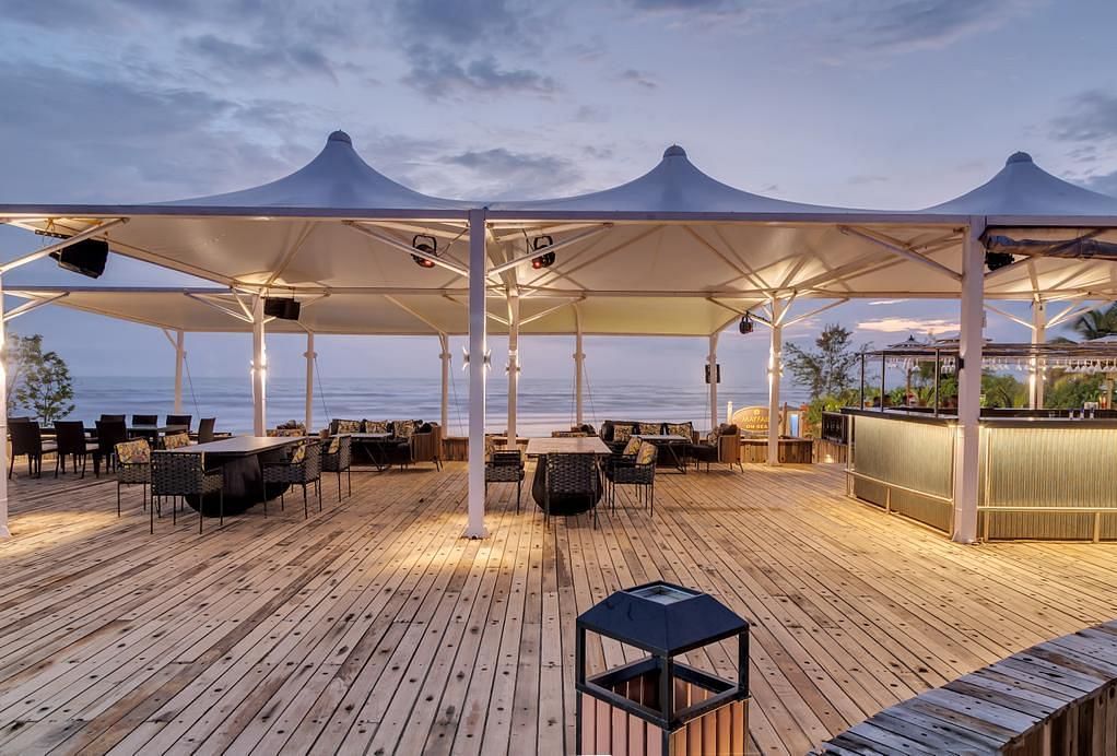 an outside cabana seating arrangement overlooking the beach - Mayfair On Sea, Morjim, Goa