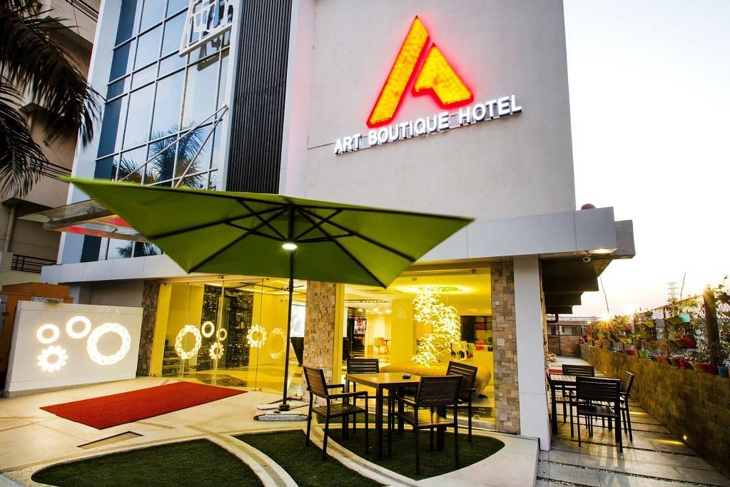Exterior view of  Art Boutique Hotel, Hyderabad, with a sitting area outisde cover with an umbrella