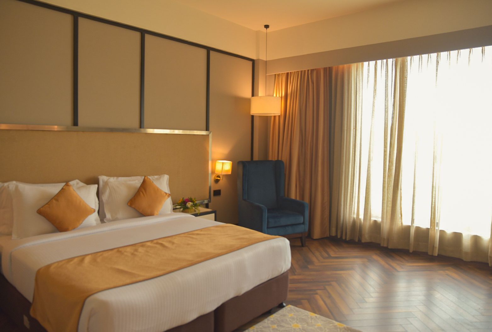A room featuring a king size bed, a couch, and ambient lighting - Polo Hotel Agartala