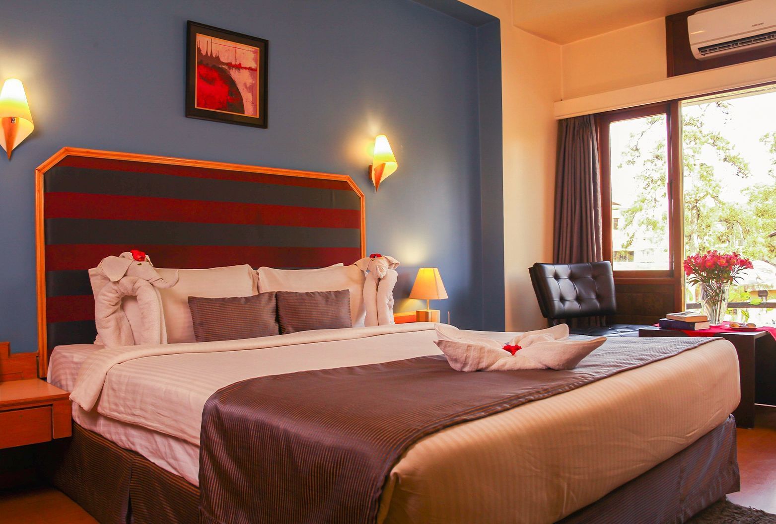 A spacious and well-lit guest room at the Polo Hotel Shillong, featuring a large bed and contemporary decor.