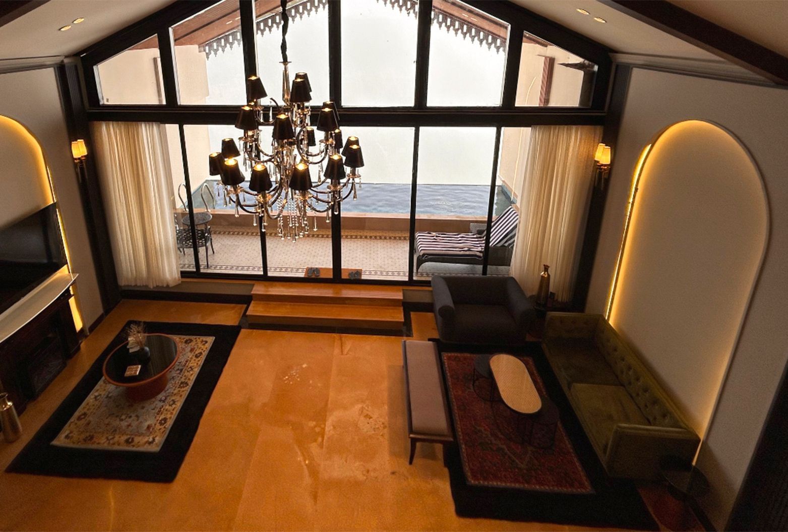 A living area within a suite at Polo Resort Cherrapunjee with a fireplace and large windows.