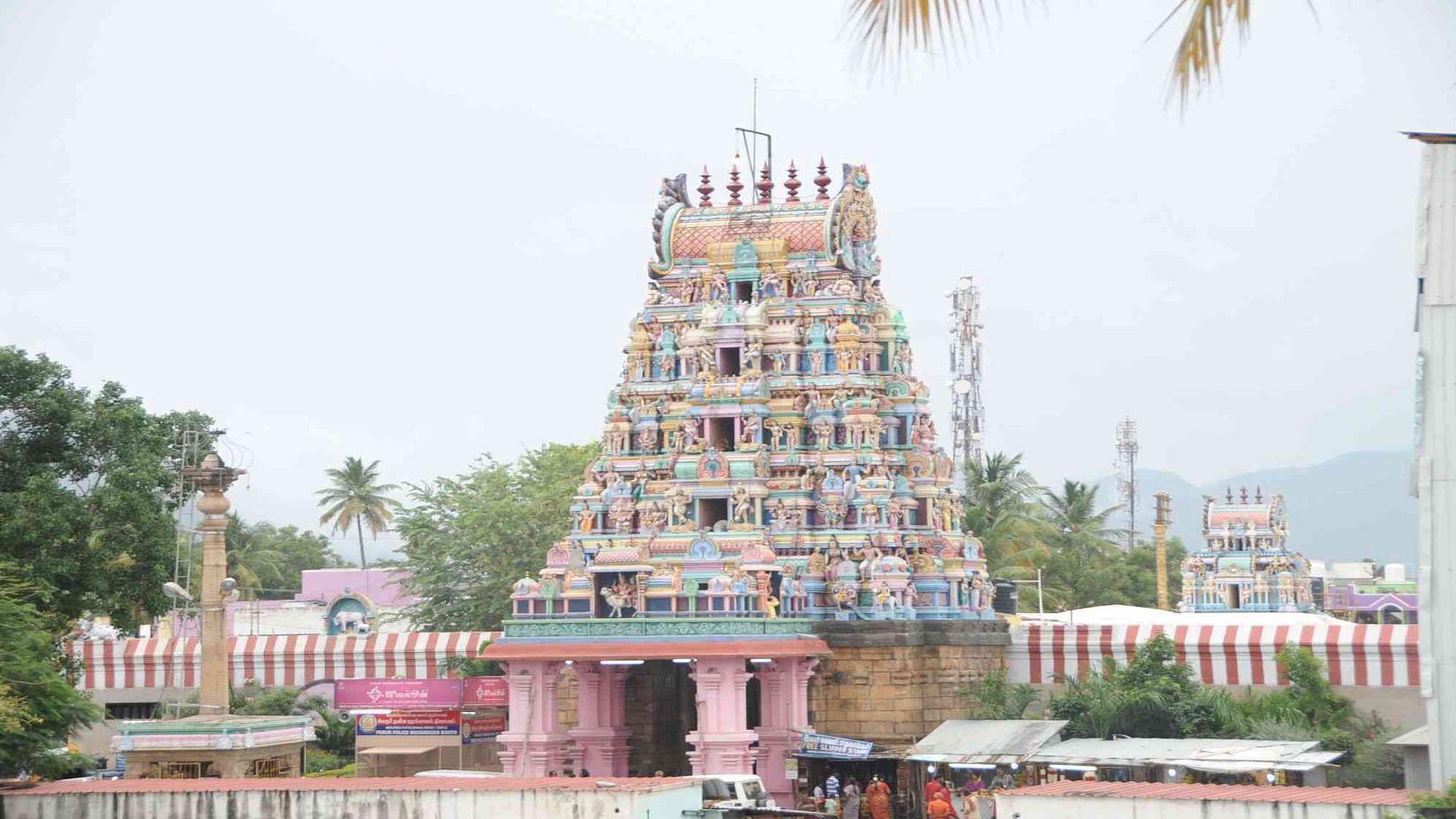 A distant view of a temple complex with intricately carved towers, set against a clear sky.