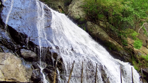  A close-up view of a powerful waterfall flowing over rocks.