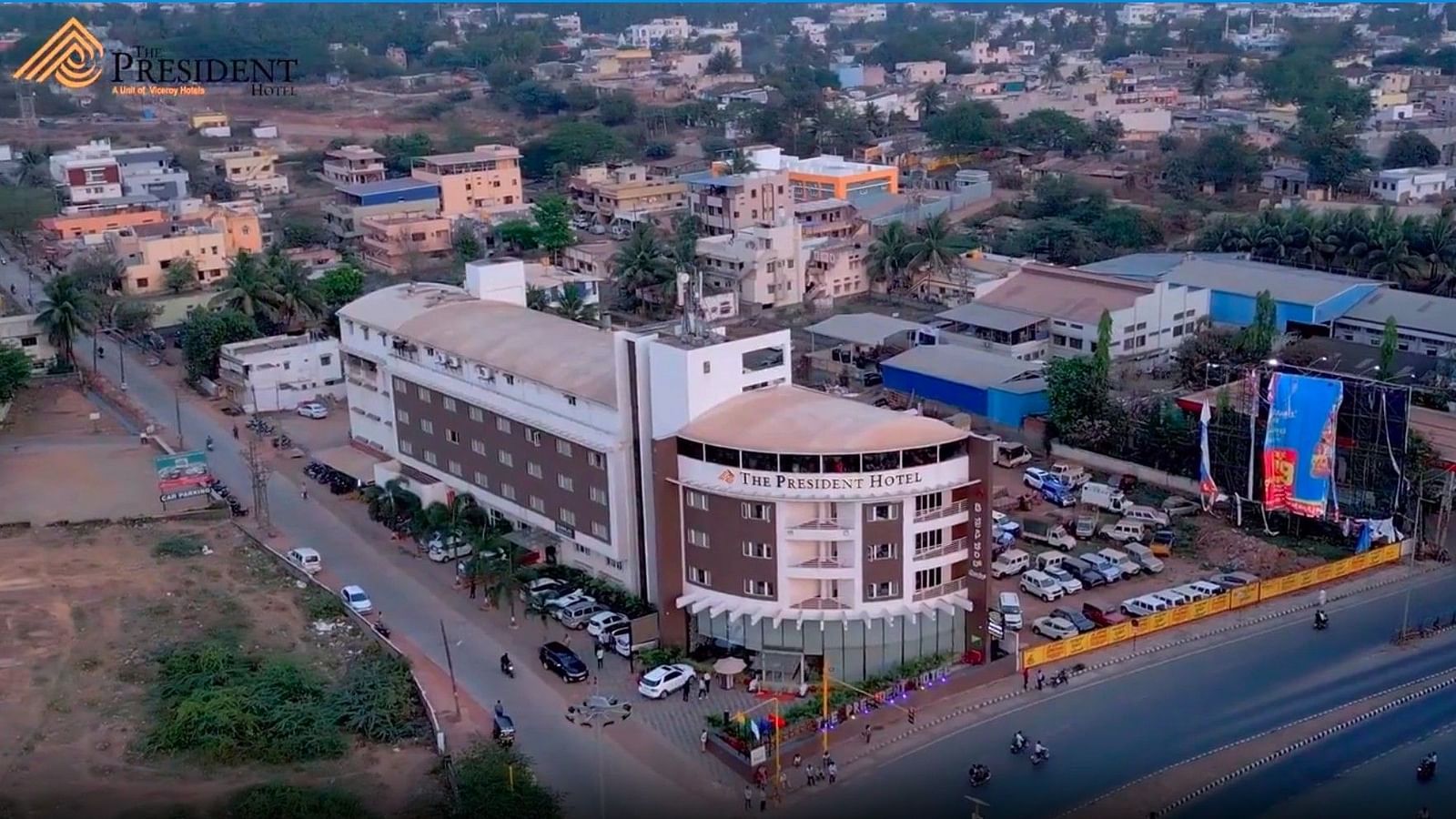 Aerial view of The President Hubli next to a main road and other buildings in the background 